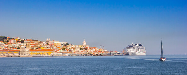 Panorama of a yacht sailing towards the historic city center of Lisbon, Portugal