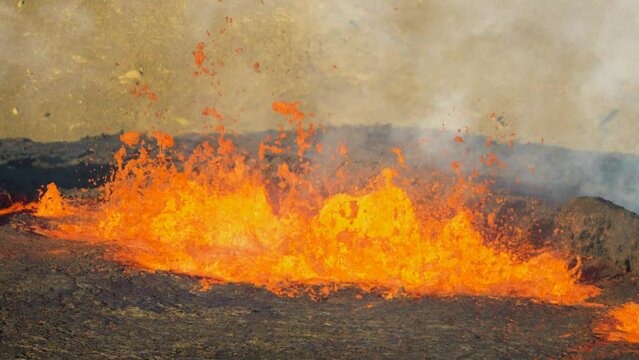 Close-up shot of volcano eruption. Magma coming out of the earth after repeated earthquakes. Lava shoots a few meters into the air.