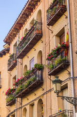 Fototapeta na wymiar Balconies with colorful flowers on houses in Segovia, Spain