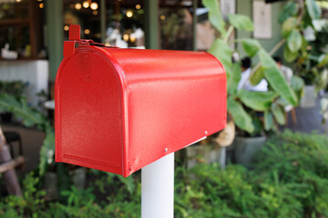 Red Mailbox with house background. red metal newspaper box with shop background.