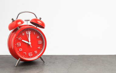 Red vintage alarm clock on wooden table on white background