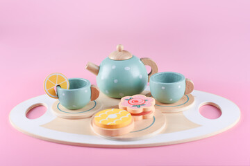 Children's tea set, fake cake and biscuit, wooden kitchenware. Cute kids toys to play in the...