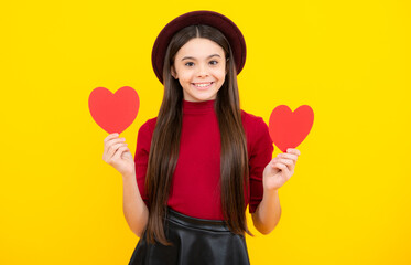 Lovely teenager portrait. Teenage girl hold shape heart, heart-shape sign. Child holding a red...
