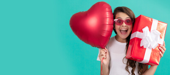 fashionable teen girl in sunglasses hold giftbox and heart balloon. love gift. surprised kid. Teenager girl with birthday gift, horizontal poster. Banner header with copy space.