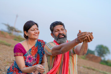 Indian farmer with wife at agriculture field.