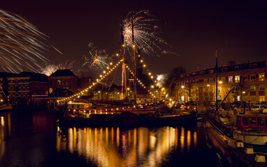 Nowy Rok w Gouda, fajerwerki nad historycznym portem, statki, światła.