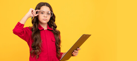 looking so smart. teen girl wear eyeglasses. kid make notes in folder on yellow background. Child builder with protective glasses horizontal poster design. Banner header, copy space.