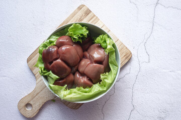 Raw fresh lamb kidneys on a chopping board 