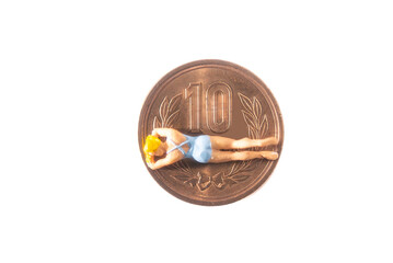 10円硬貨の上でバカンスを楽しむ女性