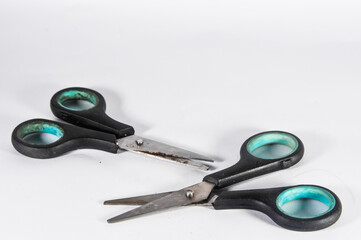 two scissors on a green and black isolated on a white background