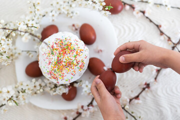 hands holding painted eggs. Easter cake