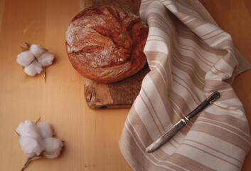 Homemade bread on the table with a cotton towel and a knife