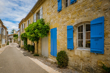 Quaint and flowery facades of townhouses with colorful wooden shutters and doors in the village of Terraube in the South of France (Gers)