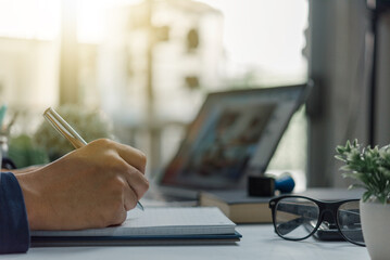 learning online class by using laptop computer and writing notebook at workplace, Education development or knowledge improvement concept.