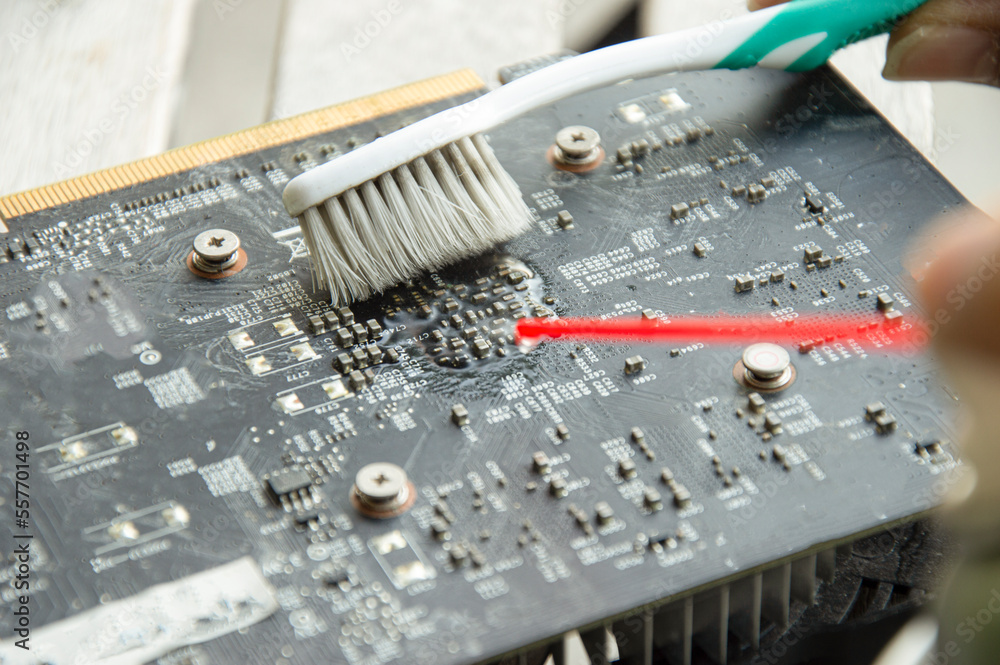 Poster mechanic's point of view use a spray and brush to clean the graphics card.