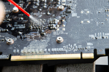 Technician view using spray to clean graphics card