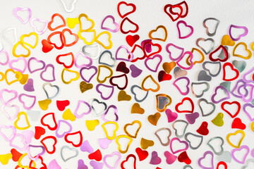Hearts made of golden glitter on a white paper texture background. Love concept.