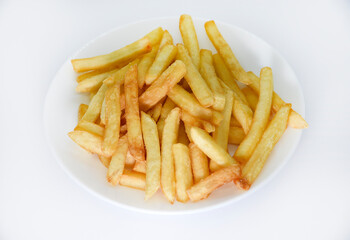 Yellow delicious French fries in white dishes. Fast food on a plate. Fried potatoes. Toasted potato slices on a white background.