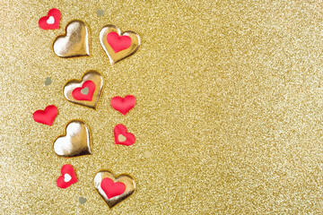 Valentines Day composition with red and golden hearts over golden glitter background with copy space. Greeting card. Valentine's Day celebration concept