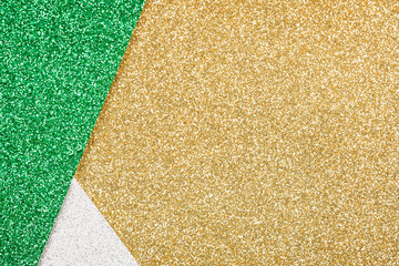 Festive glitter background - abstract geometric composition in golden, green and silver colours with copy space. Minimal fashionable style backdrop. Luxury background