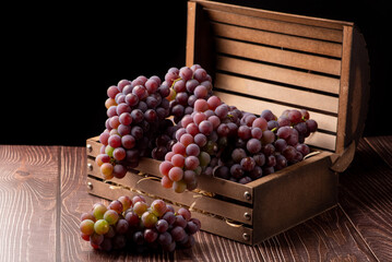 Grapes, details of beautiful grapes in a rustic box on a rustic wooden table, selective focus.