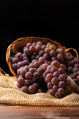 Grapes, basket with beautiful grapes and rustic fabric on rustic wood, selective focus.