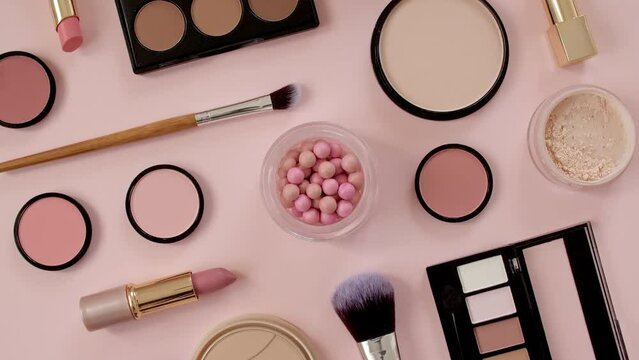 A set of decorative cosmetics on pink background. Makeup products. The beauty of the background with cosmetic facilities. Makeup, the concept of skin care with. High quality 4k footage. 4k
