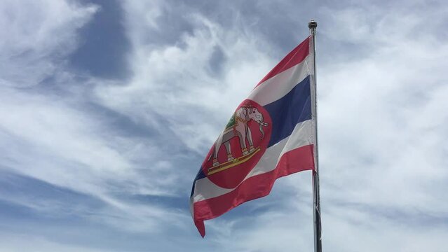 Blowing The Naval ensign of Thailand in the wind is the national flag with a red circle and white elephant on the Thai national flag background.