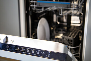 Built-in dishwasher in the kitchen, washing dishes. Plates, cups, glasses are worth washing. Household chores, everyday life