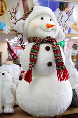 Beautiful cheerful snowman on the shelf at the supermarket. New Year's decor, Christmas toys. Vertical view.