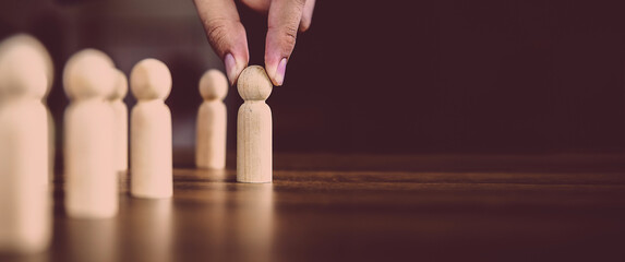 Hand choose wooden doll stand out first the group concept of relationship or HR human resources officer or business team and personnel management job performance.