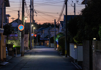 Quiet street in residential neighborhood with sunset color in sky - 557720054