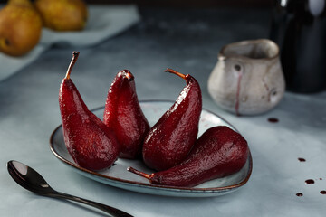 Pears poached in red wine on the blue plate