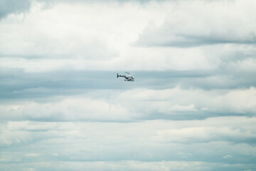 Single helicopter flying in cloudy background in NYC