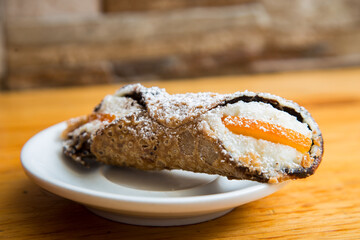 The cannolo is a typical sweet from the Italian region of Sicily, where it originates from. It consists of a rolled dough in the shape of a tube that contains ingredients mixed with ricotta.