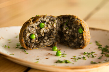 Cuttlefish black Arancini. Arancini are a specialty of Sicilian cuisine. They are stuffed breaded and fried rice balls or cones.
