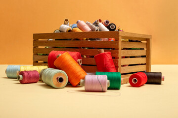 A box with multi colored coins of different threads on a colored background