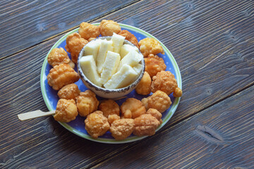 Balkan cuisine. Priganice  (small fried cakes, donuts) with cheese on dark rustic table. Copy space