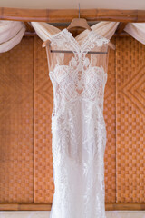 wedding dress on hanger on a wall.