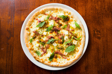 Pizza with arugula meat and cheese. Neapolitan pizza made with mozzarella. Italian recipe.