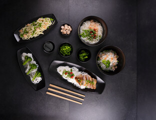 Various dishes of Asian cuisine with different types noodles and rice with shrimp, duck, vegetables and black sesame