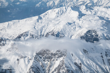 Naklejka premium Low clouds drifting through mountain landscapes in Alps