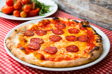 Salami Pizza. Neapolitan pizza made with salami, cheese and baked vegetables. Italian recipe.
