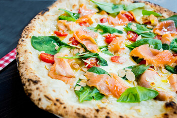 Salmon Pizza. Neapolitan pizza made with salmon and baked vegetables. Italian vegetarian recipe.