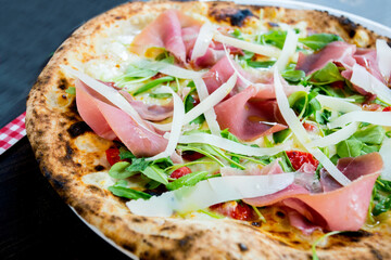 Serrano ham pizza. Neapolitan pizza made with baked vegetables and serrano ham. Italian recipe.