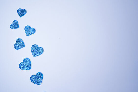 Glittering blue hearts on white background. Valentines day concept. Womens day. Copy space. Flat lay.