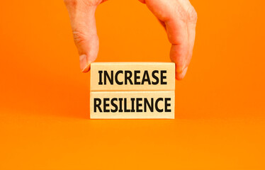 Increase resilience symbol. Concept word Increase resilience typed on wooden blocks. Beautiful orange table orange background. Businessman hand. Business and increase resilience concept. Copy space.