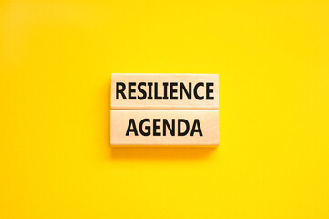Resilience agenda symbol. Concept word Resilience agenda typed on wooden blocks. Beautiful yellow table yellow background. Business and resilience agenda concept. Copy space.