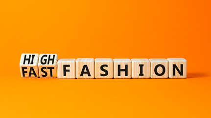 Fast or high fashion symbol. Concept words Fast fashion and High fashion on wooden cubes. Beautiful orange table orange background. Business fast or high fashion concept. Copy space.