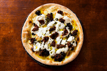 Bufala and black olives Pizza. Neapolitan pizza made with tomato sauce, mozzarella cheese and some vegetables. Italian recipe.